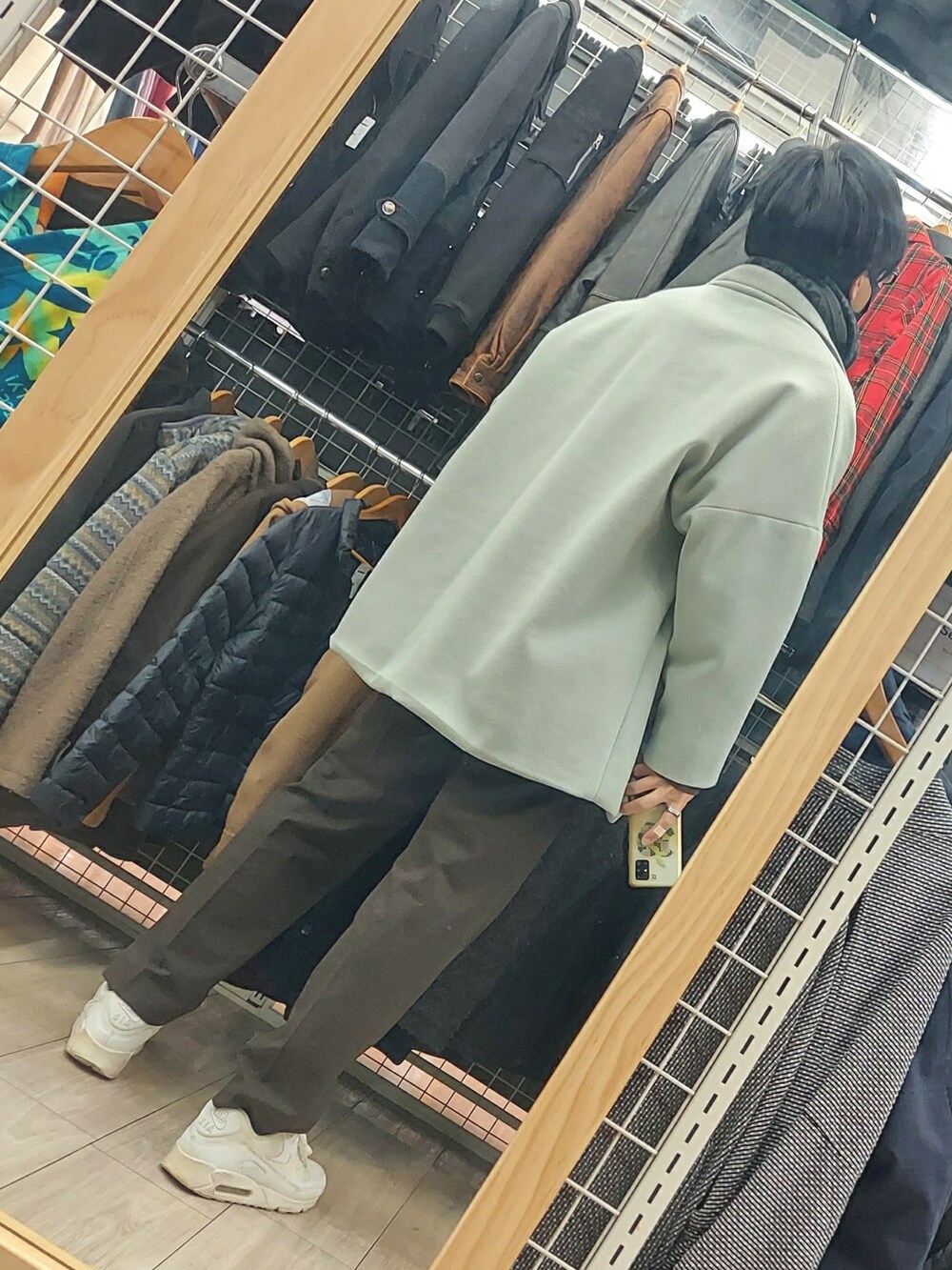 ブラウン系のパンツ、グリーン系のジャケット/アウター、ホワイト系のスニーカーを着用したメンズの冬コーディネートの2枚目の写真