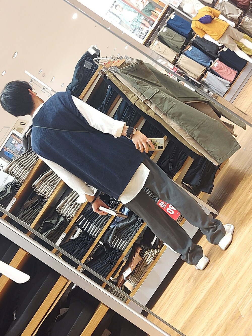 ホワイト系のスニーカー、ブルー系のパンツ、ブルー系のベストを着用したメンズの春コーディネートの2枚目の写真
