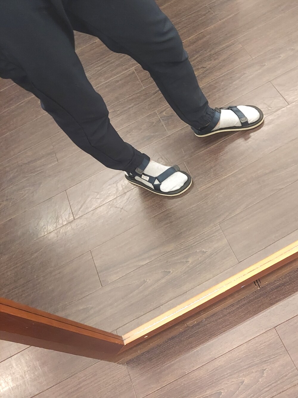ブラック系のサンダル、ブルー系のパンツ、ホワイト系のビジネスシャツを着用したメンズの夏コーディネートの3枚目の写真