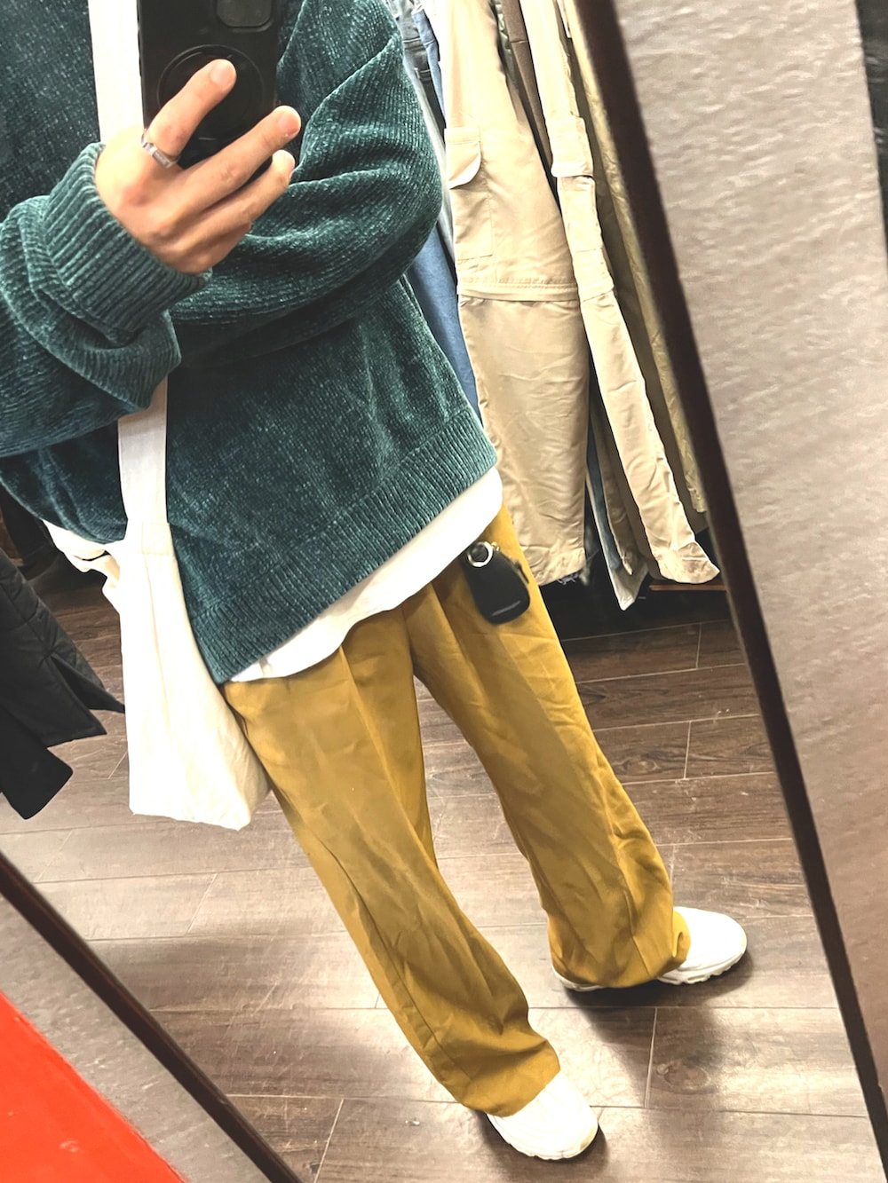 ホワイト系のスニーカー、グリーン系のニット/セーター、オレンジ系のパンツを着用したメンズの秋コーディネートの3枚目の写真