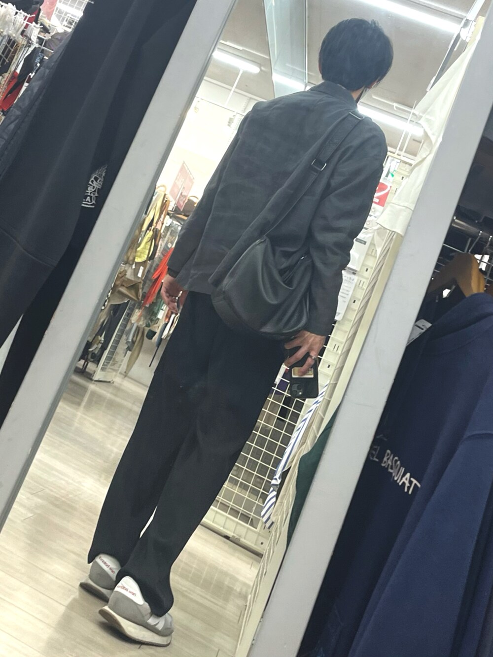 ブラック系のスラックス、グレー系のスニーカー、グレー系のテーラードジャケットを着用したメンズの春コーディネートの2枚目の写真