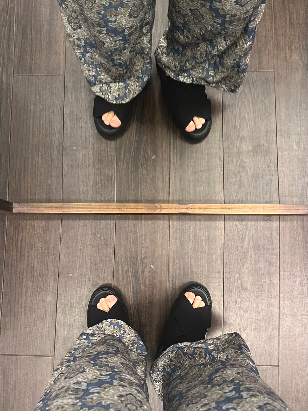 ブラック系のサンダル、ブルー系のパンツ、ベージュ系のベストを着用したメンズの秋コーディネートの5枚目の写真