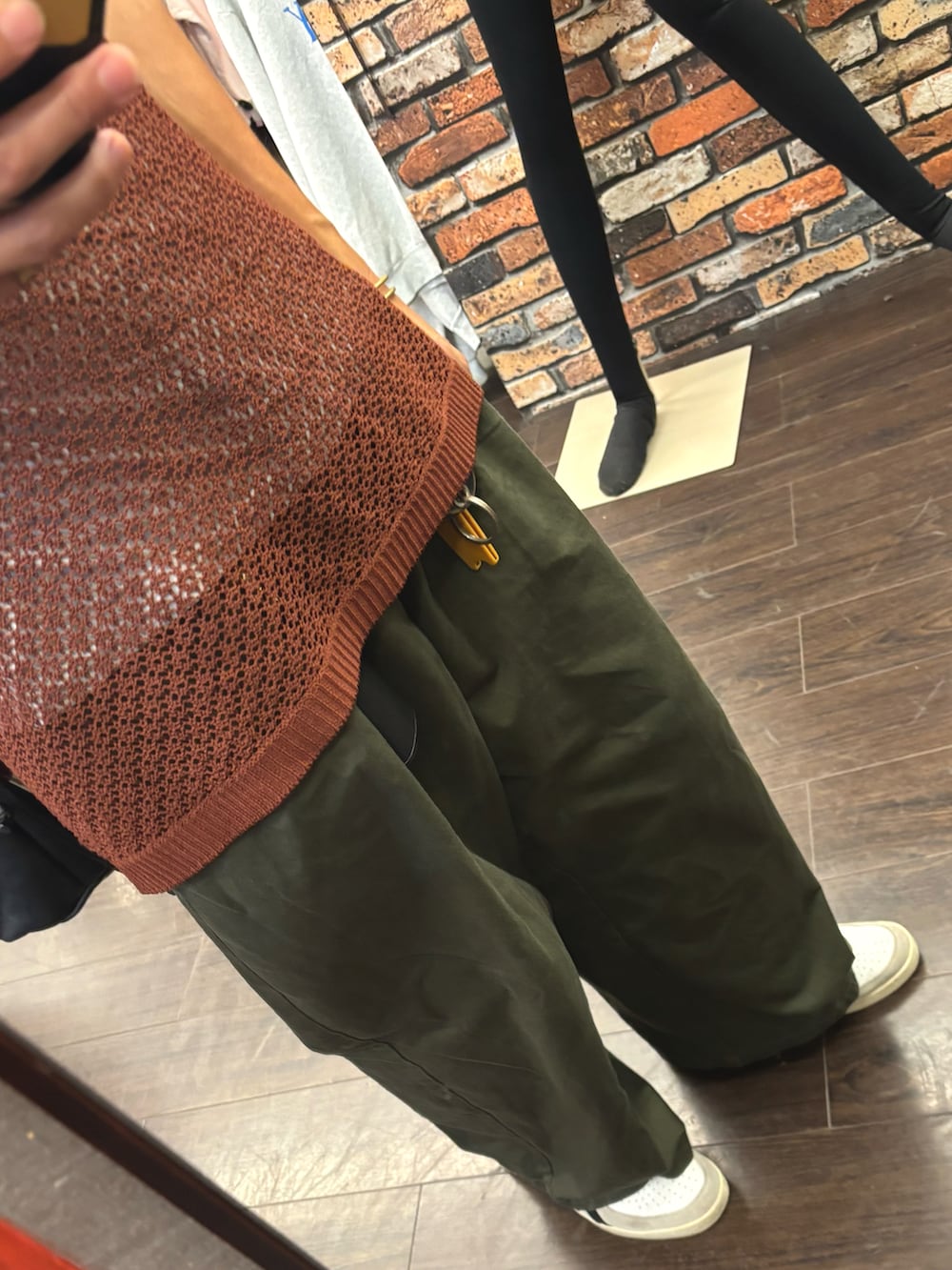 レッド系のポロシャツ、ホワイト系のスニーカー、グリーン系のパンツを着用したメンズの夏コーディネートの3枚目の写真