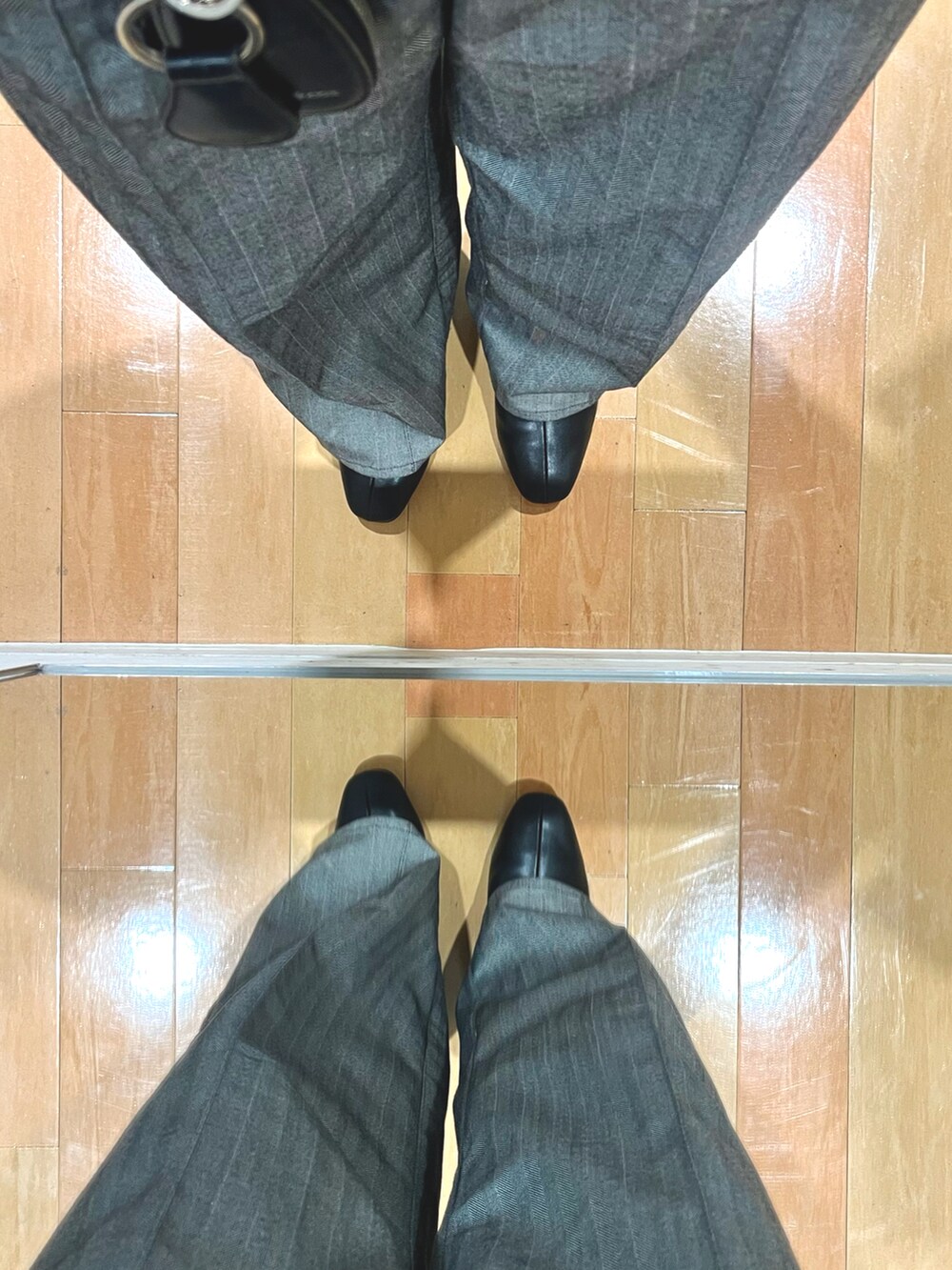 グレー系のスラックス、ブラック系のショルダーバッグ、パープル系のニット/セーターを着用したメンズの冬コーディネートの5枚目の写真