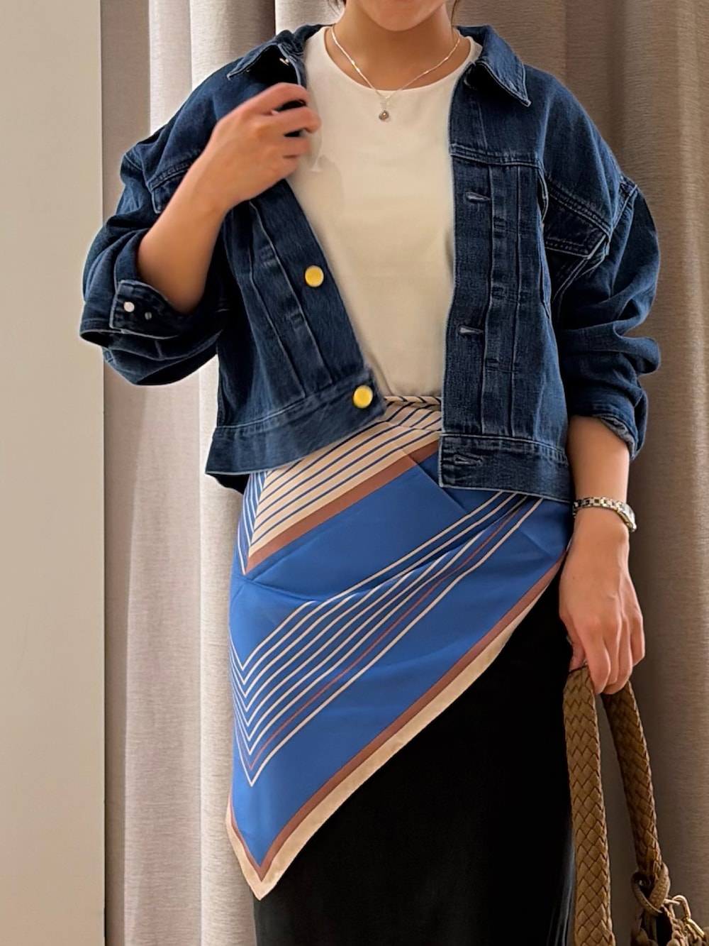 ブラック系のスカート、ブルー系のデニムジャケット、ホワイト系のTシャツ/カットソーを着用したレディースの夏コーディネートの2枚目の写真