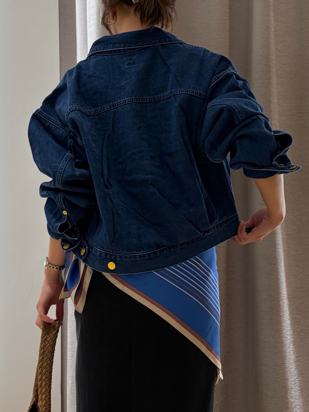 ブラック系のスカート、ブルー系のデニムジャケット、ホワイト系のTシャツ/カットソーを着用したレディースの夏コーディネートの3枚目の写真