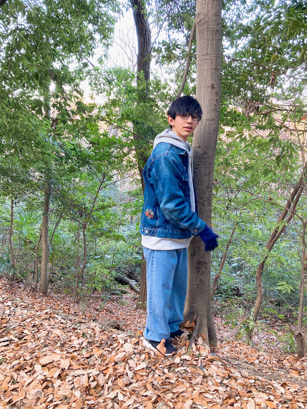 グレー系のパーカー、ブルー系のデニムジャケット、ブルー系のデニムパンツを着用したメンズの冬コーディネートの2枚目の写真