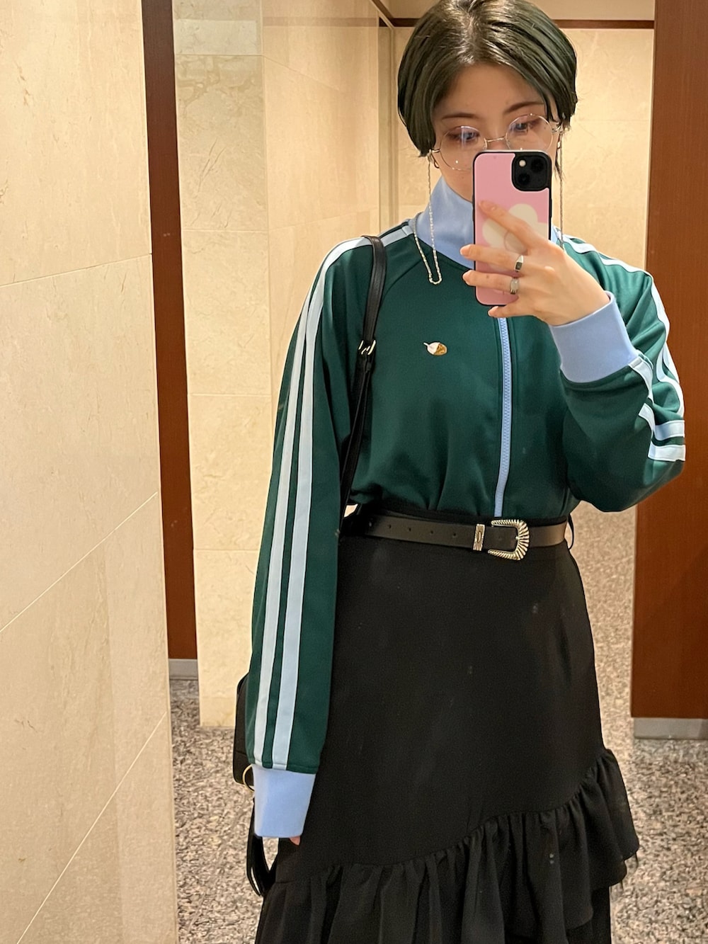 ブラック系のスカート、グリーン系のジャージを着用したレディースの冬コーディネートの3枚目の写真