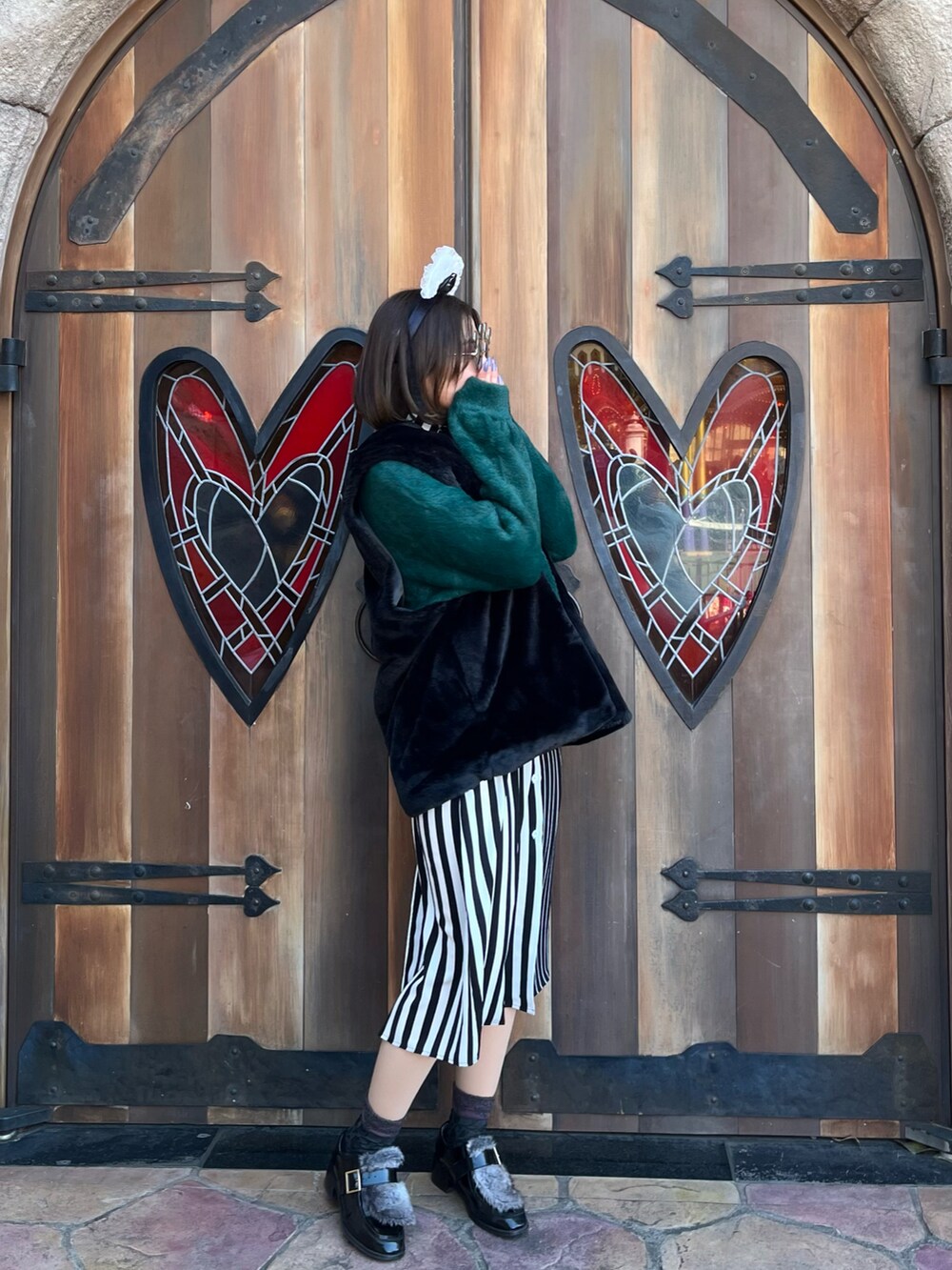 ブラック系のその他アウター、グリーン系のニット/セーター、ブラック系のワンピースを着用したレディースの冬コーディネートの3枚目の写真