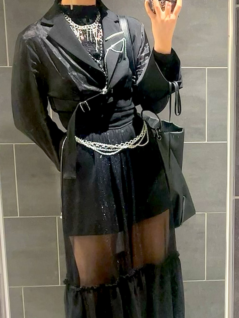 ブラック系のワンピース、ブラック系のテーラードジャケット、ブラック系のブーツを着用したレディースの春コーディネートの2枚目の写真