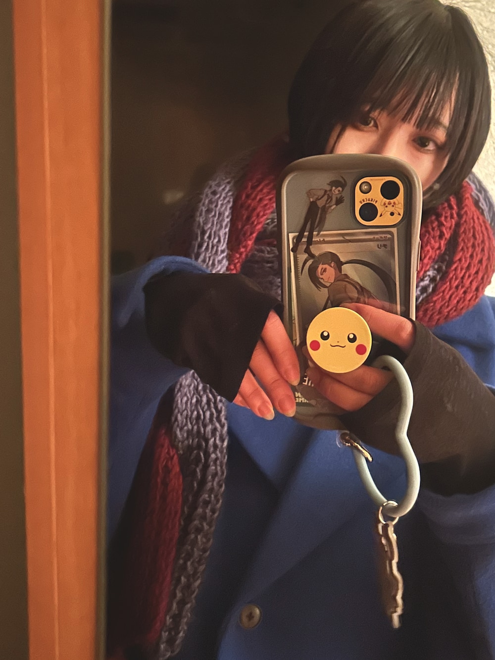 ブラック系のブーツ、ブルー系のチェスターコート、レッド系のスウェットを着用したレディースの冬コーディネートの3枚目の写真