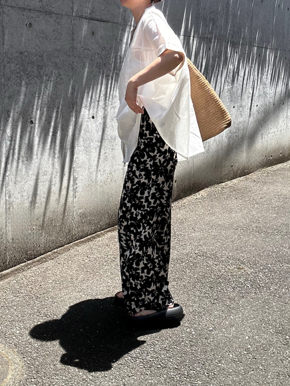 ホワイト系のシャツ/ブラウス、ブラック系のパンツを着用したレディースの夏コーディネートの2枚目の写真
