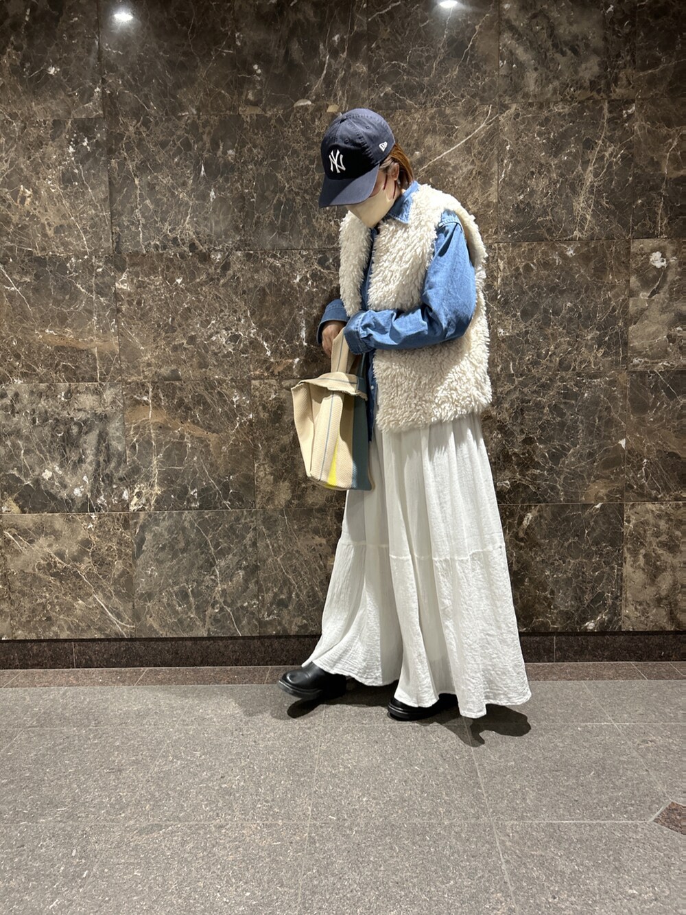 ホワイト系のスカート、ホワイト系のベスト、ブルー系のシャツ/ブラウスを着用したレディースの春コーディネートの2枚目の写真