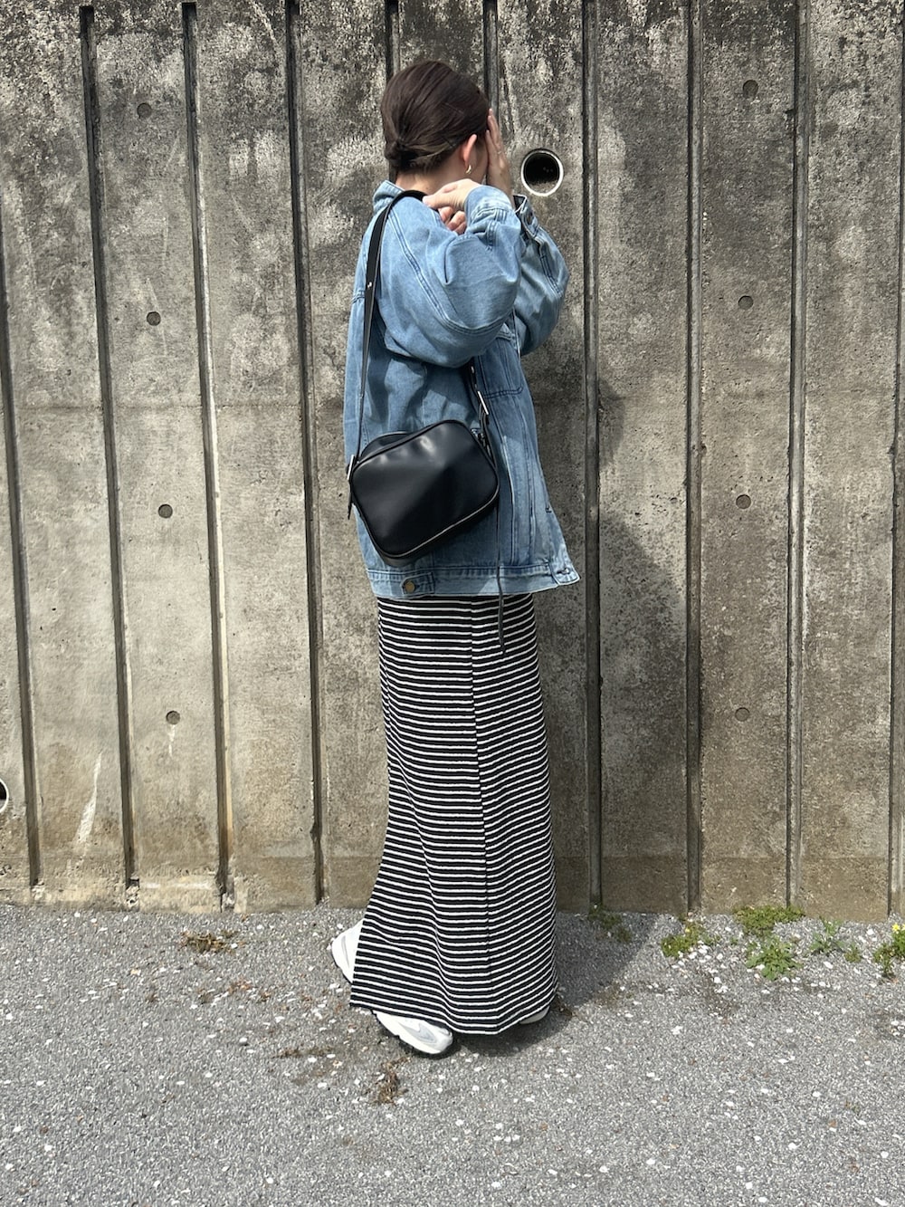 ブラック系のスカート、ホワイト系のTシャツ/カットソー、ブルー系のデニムジャケットを着用したレディースの春コーディネートの2枚目の写真