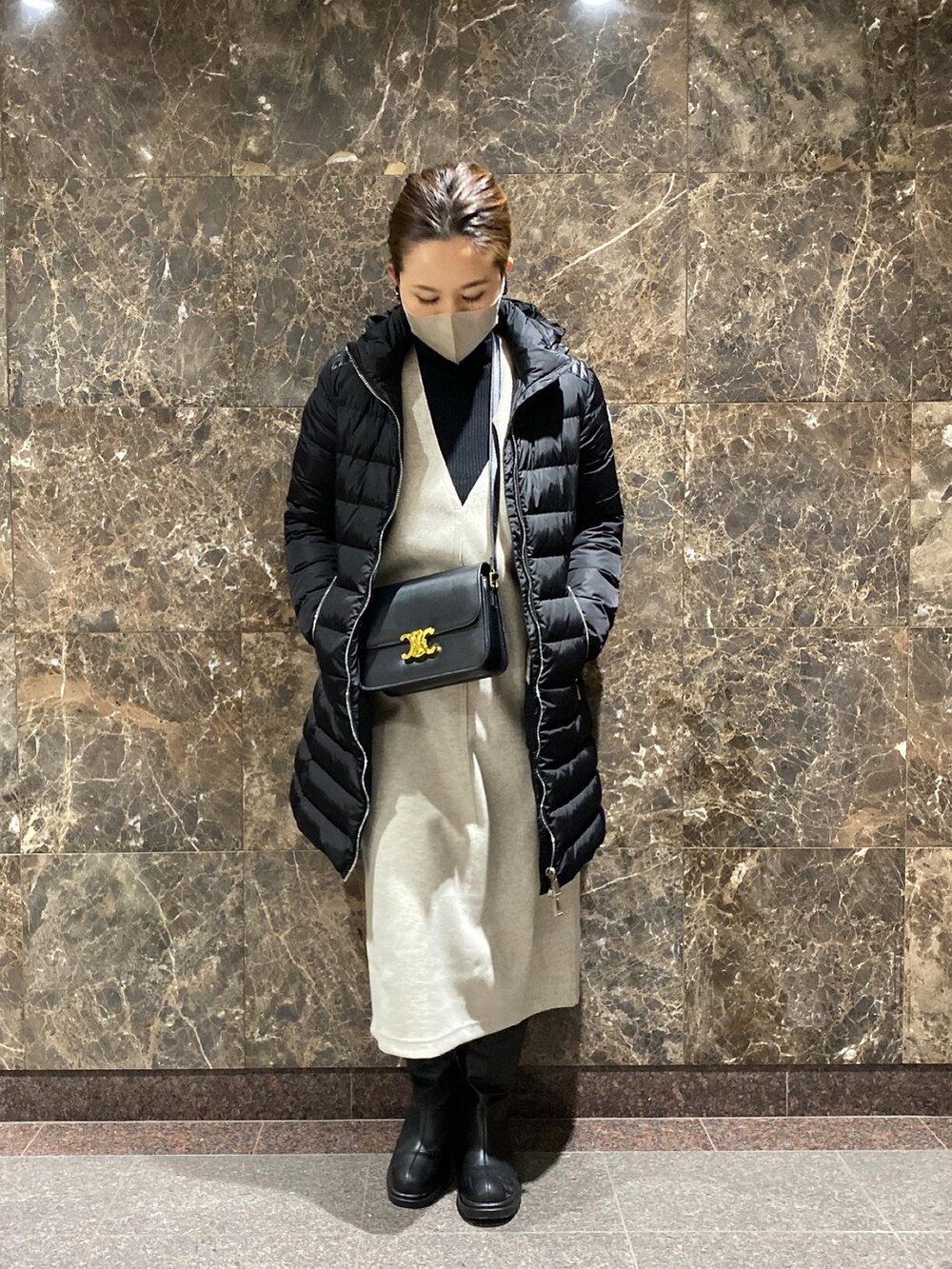 ブラック系のショルダーバッグ、ホワイト系のジャンパースカート、ブラック系のニット/セーターを着用したレディースの冬コーディネートの5枚目の写真