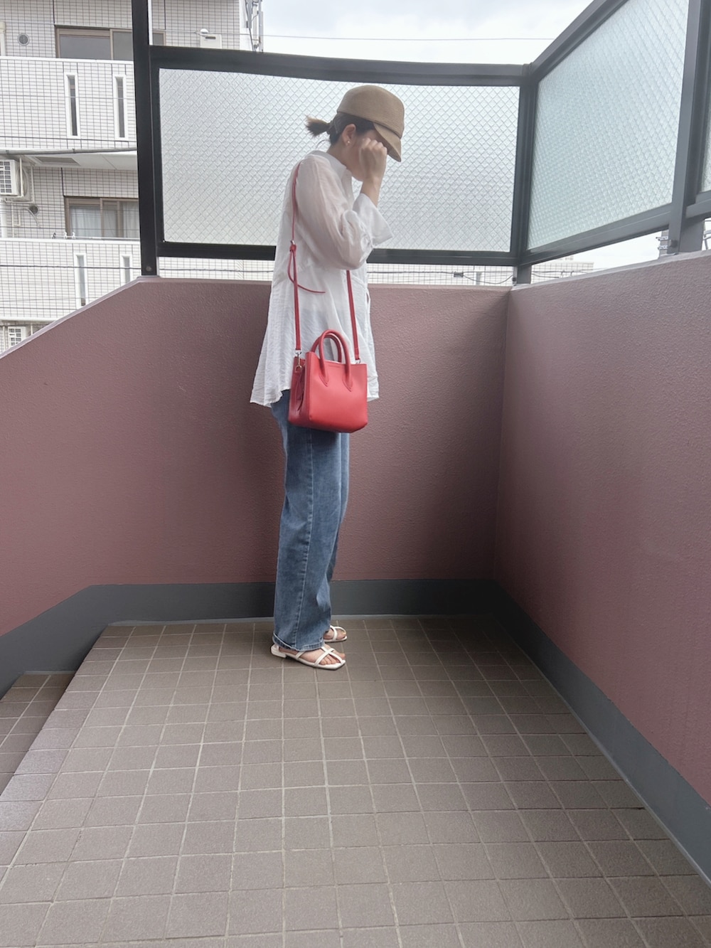 ブルー系のデニムパンツ、ホワイト系のサンダル、ホワイト系のシャツ/ブラウスを着用したレディースの夏コーディネートの2枚目の写真