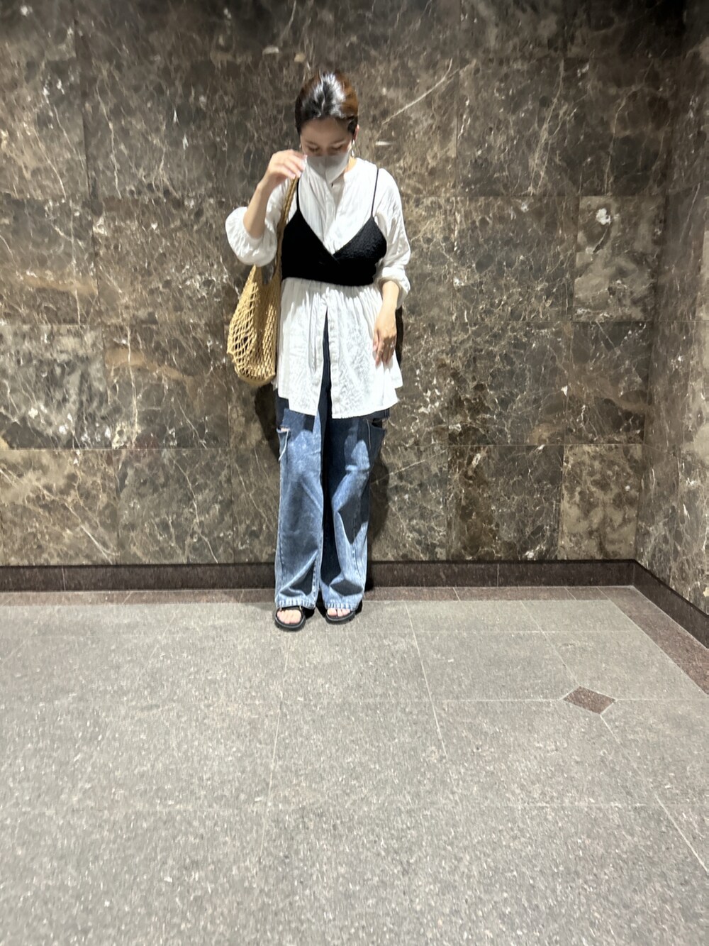 ホワイト系のトップス、ブルー系のデニムパンツを着用したレディースの春コーディネートの2枚目の写真