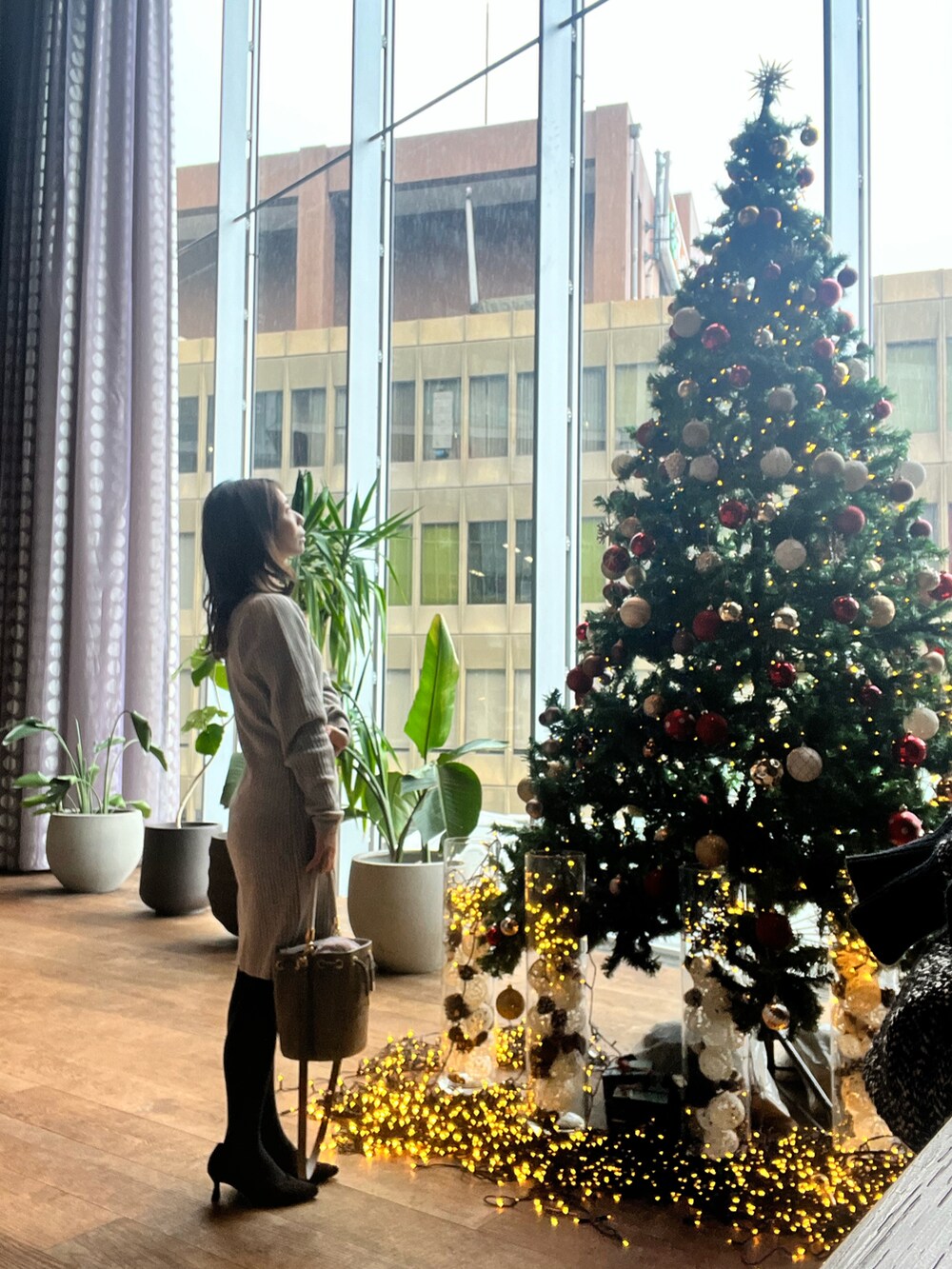 グレー系のショルダーバッグ、ブラック系のパンプス、グレー系のワンピースを着用したレディースの秋コーディネートの2枚目の写真