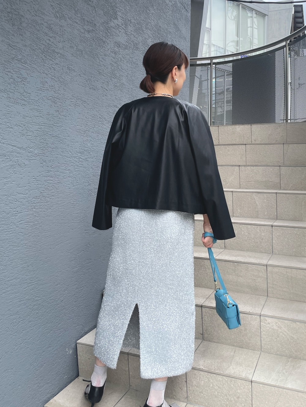 ブルー系のショルダーバッグ、ブラック系のサンダル、ブラック系のブルゾンを着用したレディースの秋コーディネートの9枚目の写真