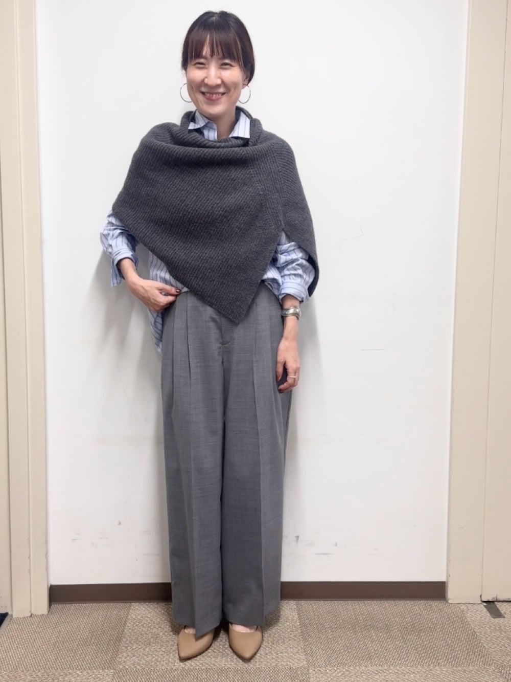グレー系のニット/セーター、グレー系のその他パンツ、ブルー系のシャツ/ブラウスを着用したレディースの秋コーディネートの8枚目の写真
