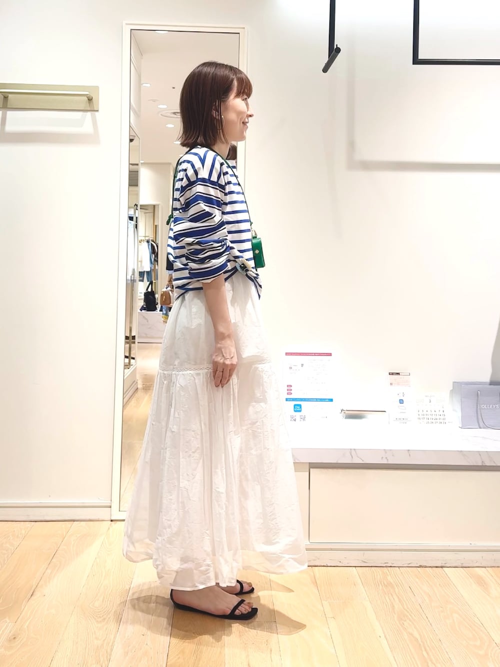 ブルー系のTシャツ/カットソー、グリーン系のチャーム、ベージュ系のヘアゴムを着用したレディースの春コーディネートの6枚目の写真