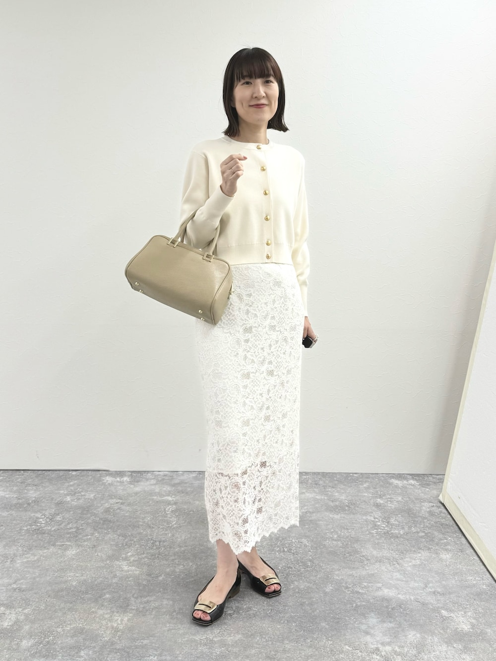 ホワイト系のカーディガン/ボレロ、ベージュ系のショルダーバッグ、ホワイト系のスカートを着用したレディースの秋コーディネートの4枚目の写真