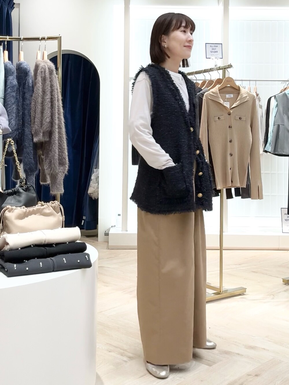 イエロー系のその他パンツ、ブルー系のベスト、ベージュ系のTシャツ/カットソーを着用したレディースの秋コーディネートの4枚目の写真