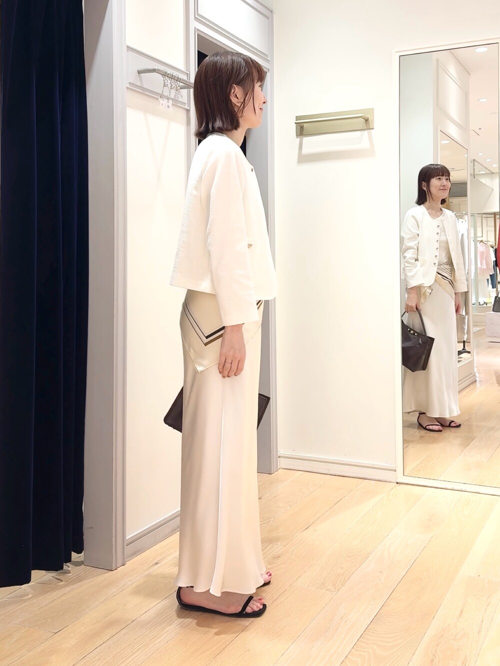 ホワイト系のタンクトップ、ホワイト系のノーカラージャケット、ホワイト系のスカートを着用したレディースの春コーディネートの6枚目の写真