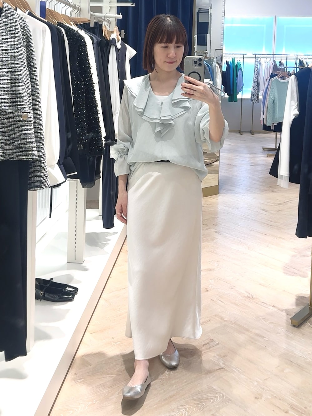 ホワイト系のスカート、グリーン系のシャツ/ブラウス、ホワイト系のタンクトップを着用したレディースの春コーディネートの4枚目の写真