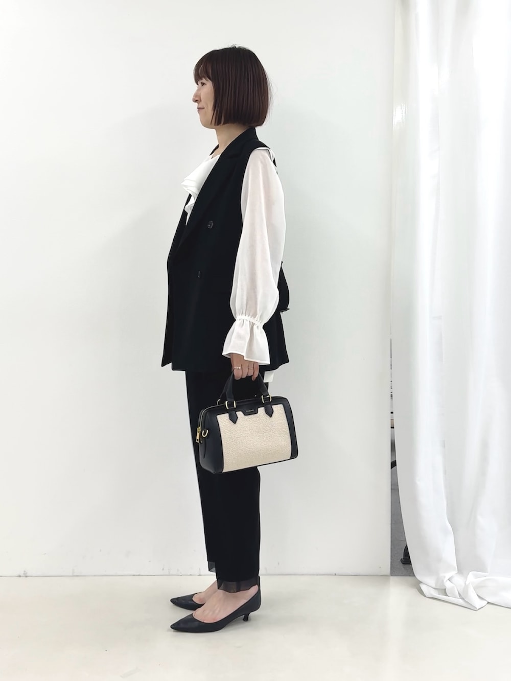 ブラック系のベスト、ホワイト系のシャツ/ブラウス、ブラック系のその他パンツを着用したレディースの冬コーディネートの5枚目の写真