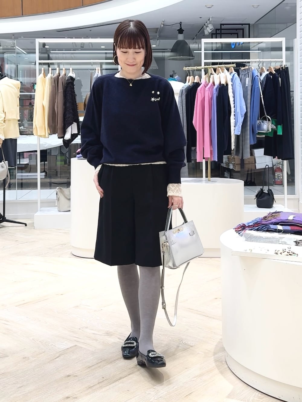 ブルー系のニット/セーター、ブラック系のその他パンツ、ホワイト系のカーディガン/ボレロを着用したレディースの冬コーディネートの3枚目の写真