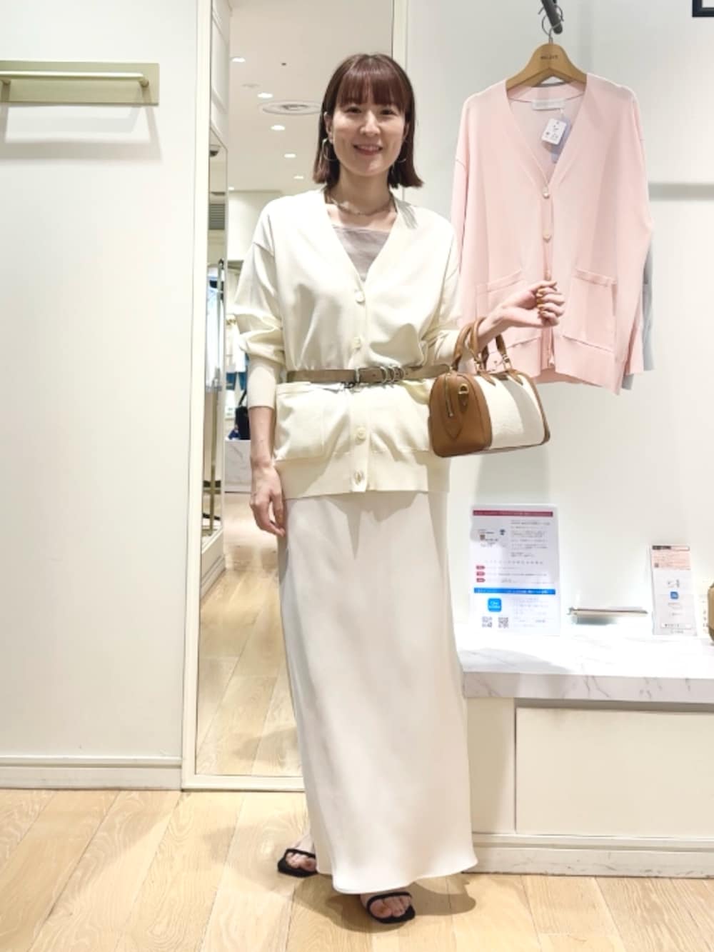 ベージュ系のタンクトップ、ホワイト系のスカート、ブラウン系のボストンバッグを着用したレディースの春コーディネートの5枚目の写真