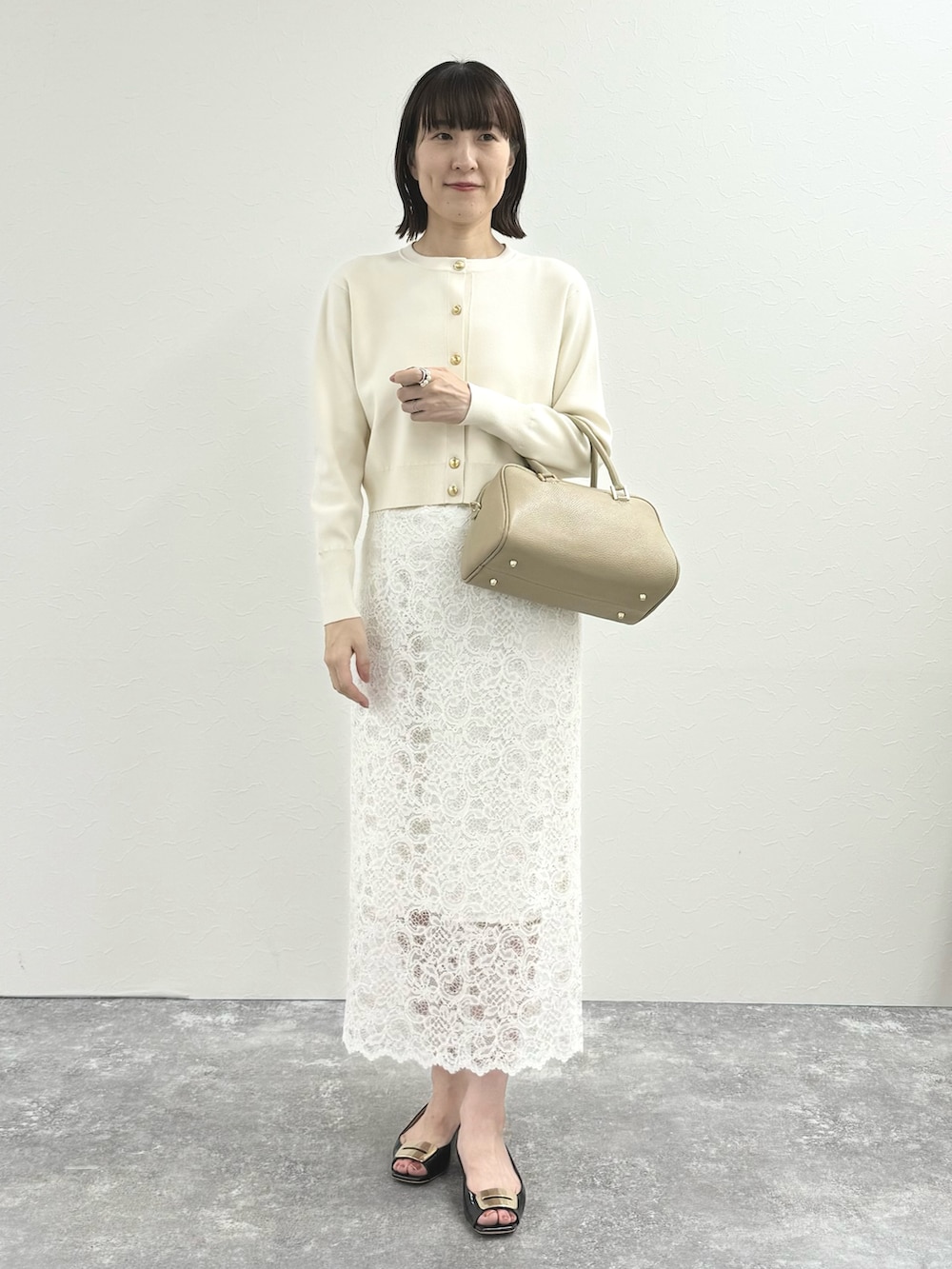 ホワイト系のカーディガン/ボレロ、ベージュ系のショルダーバッグ、ホワイト系のスカートを着用したレディースの秋コーディネートの5枚目の写真