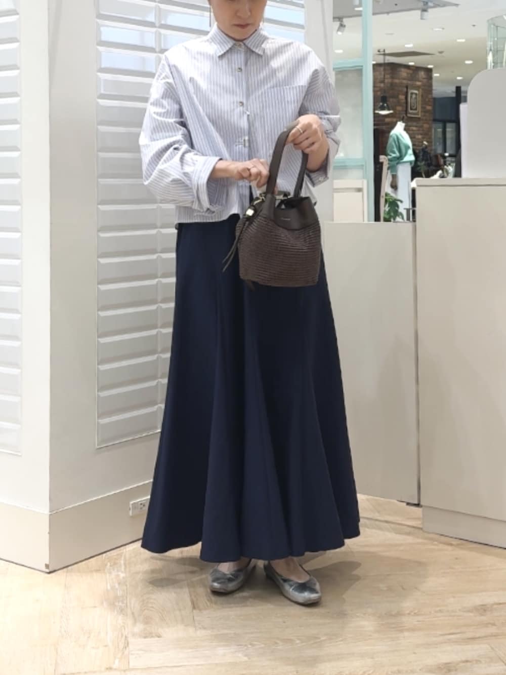 ブルー系のシャツ/ブラウス、ブルー系のスカート、ブラウン系のショルダーバッグを着用したレディースの春コーディネートの7枚目の写真