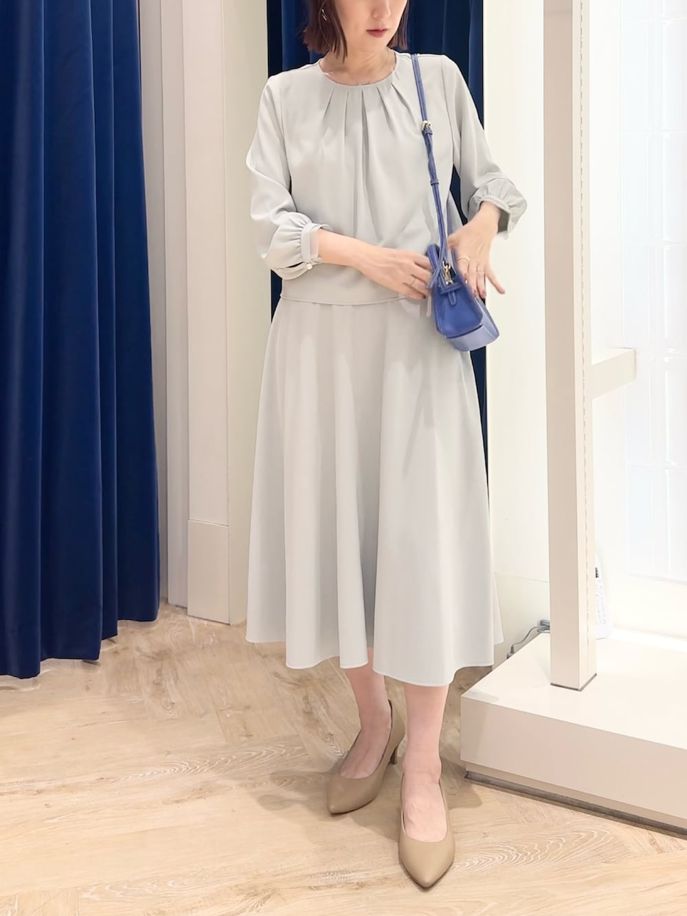 ブルー系のスカート、ブルー系のシャツ/ブラウス、ホワイト系のショルダーバッグを着用したレディースの秋コーディネートの2枚目の写真