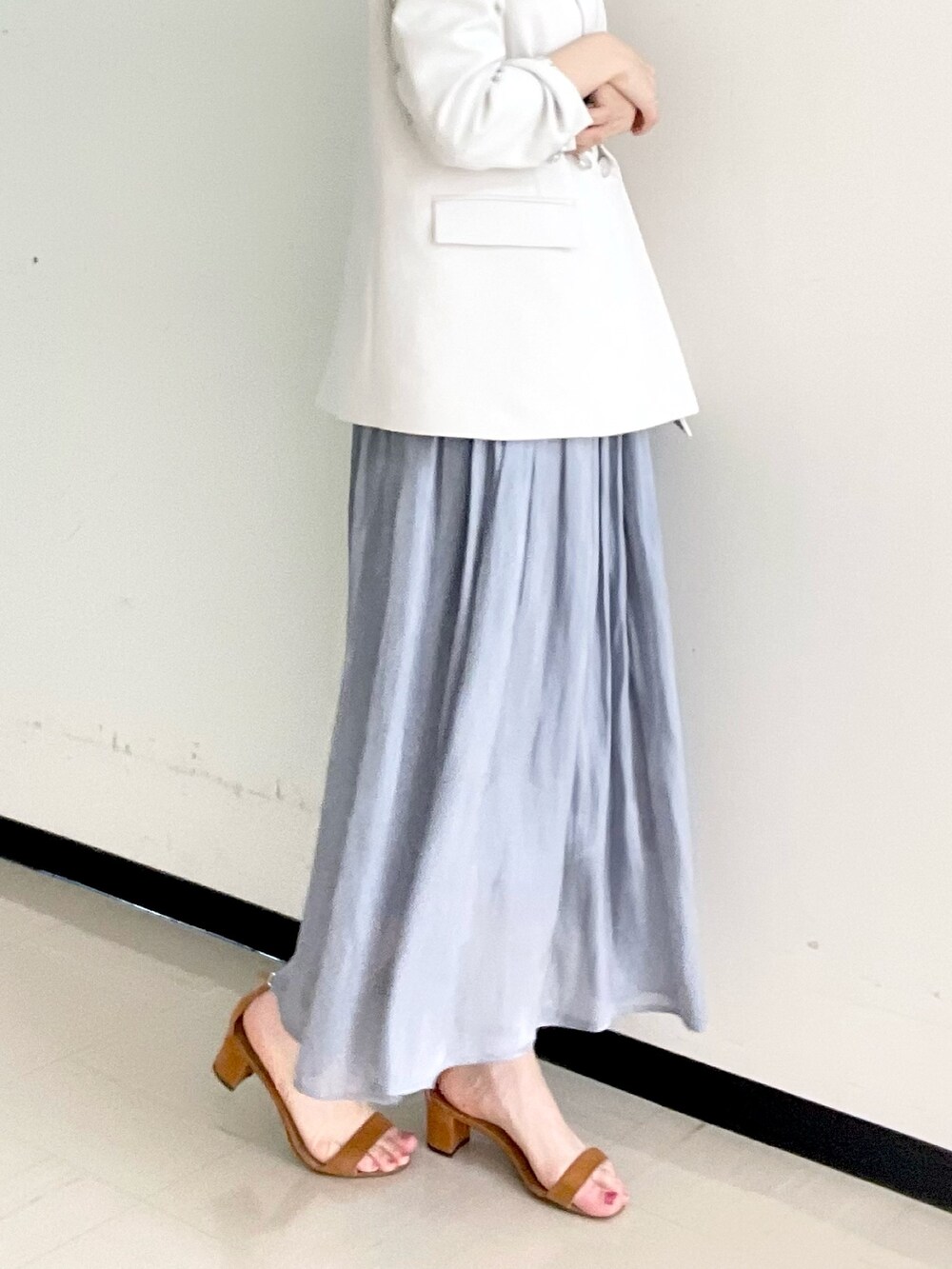 ホワイト系のニット/セーター、ベージュ系のテーラードジャケット、ゴールド系のイヤリングを着用したレディースの冬コーディネートの4枚目の写真