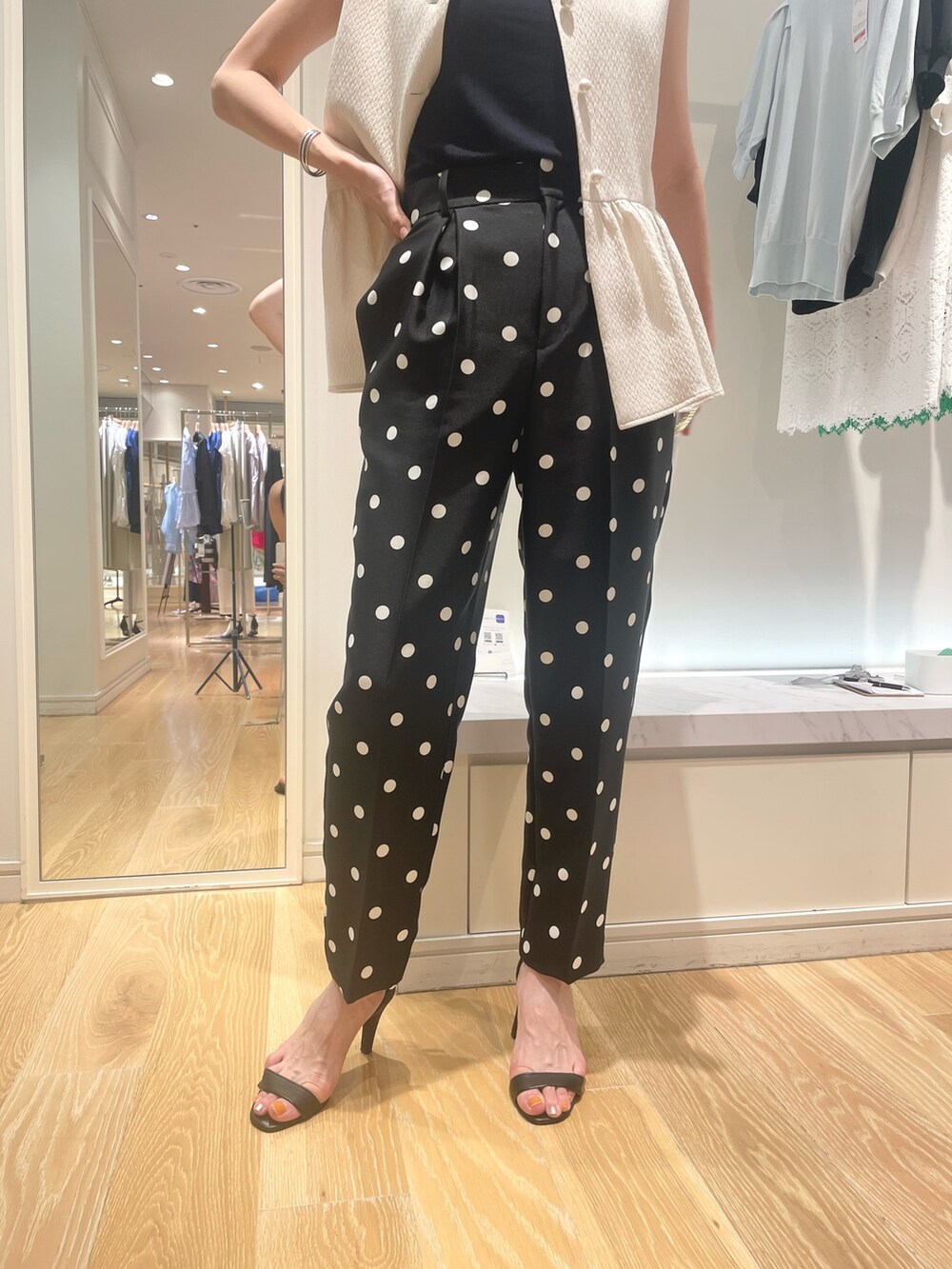 ホワイト系のベスト、ブラック系のその他パンツ、ブルー系のショルダーバッグを着用したレディースの夏コーディネートの3枚目の写真