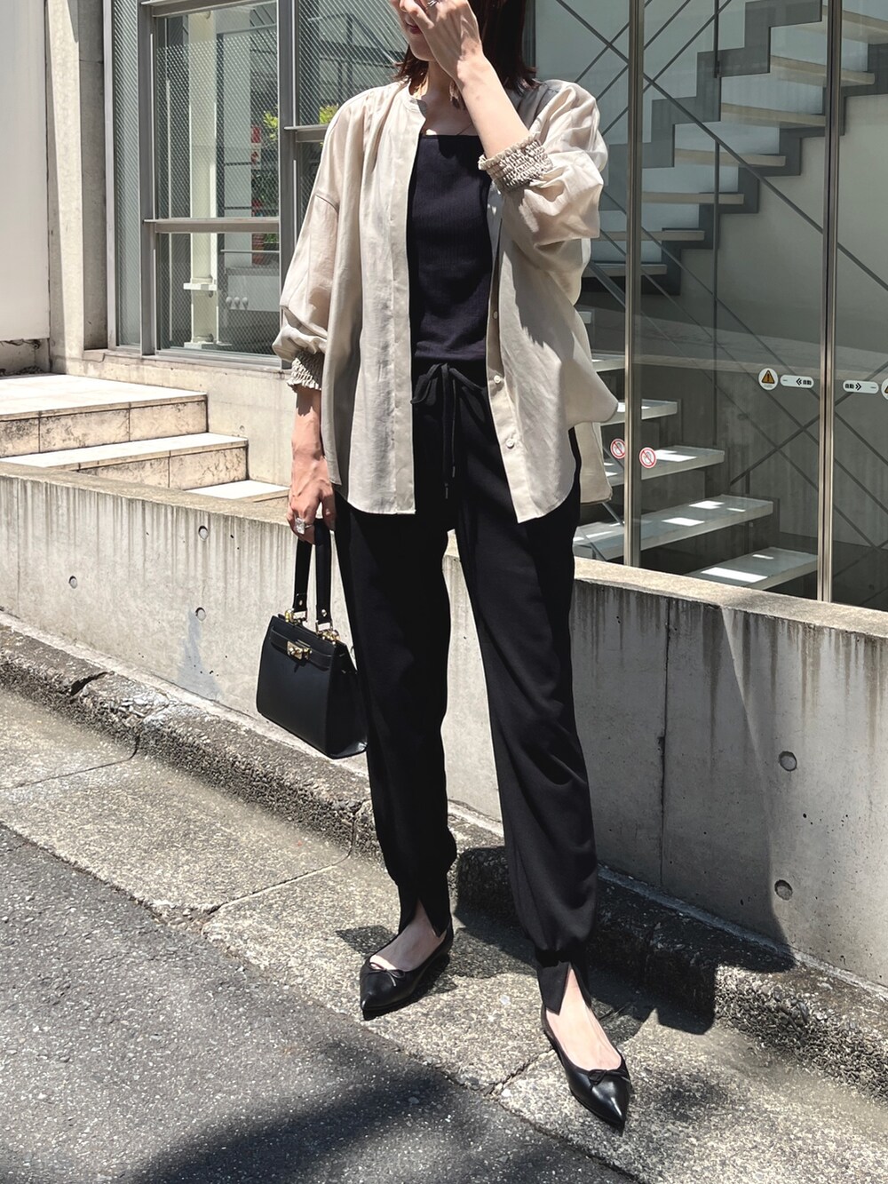 ブラック系のショルダーバッグ、ベージュ系のシャツ/ブラウス、ブラック系のその他パンツを着用したレディースの夏コーディネートの7枚目の写真