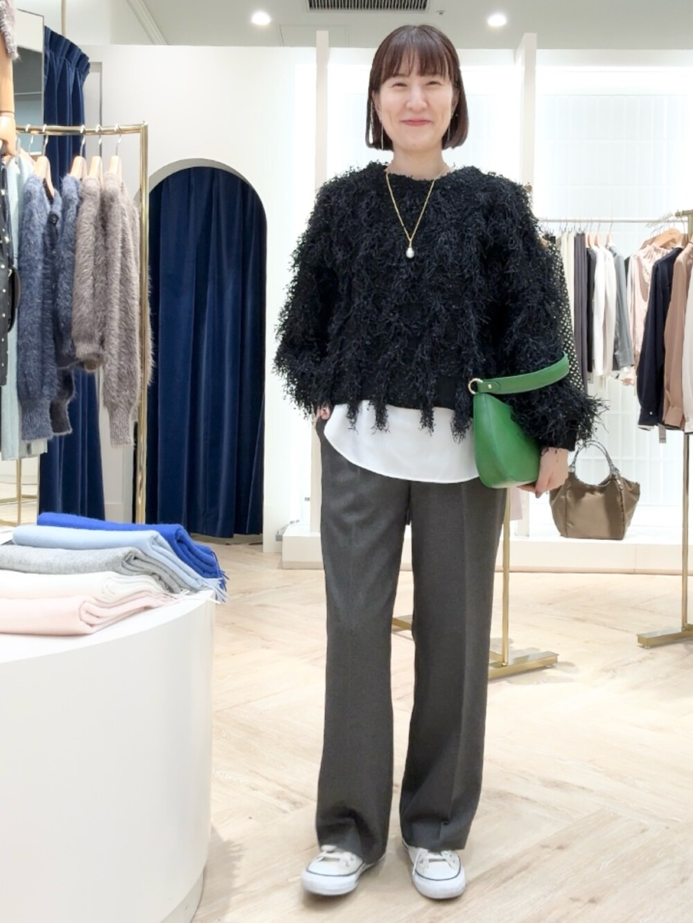 グレー系のその他パンツ、ホワイト系のシャツ/ブラウス、ブラック系のニット/セーターを着用したレディースの秋コーディネートの4枚目の写真