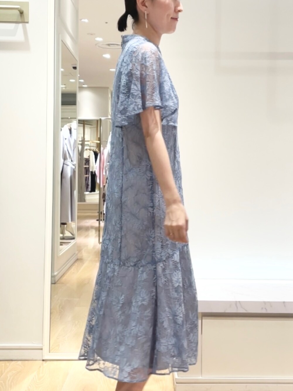 ベージュ系のショルダーバッグ、ブルー系のワンピース、ゴールド系のイヤリングを着用したレディースの秋コーディネートの7枚目の写真