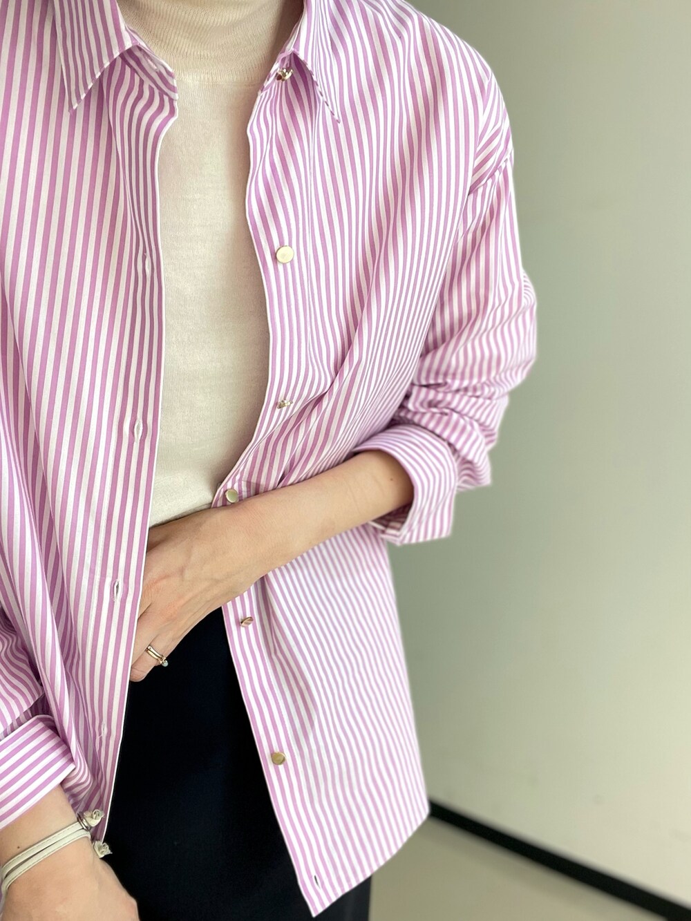 ブラック系のスカート、ホワイト系のニット/セーター、ピンク系のシャツ/ブラウスを着用したレディースの冬コーディネートの2枚目の写真