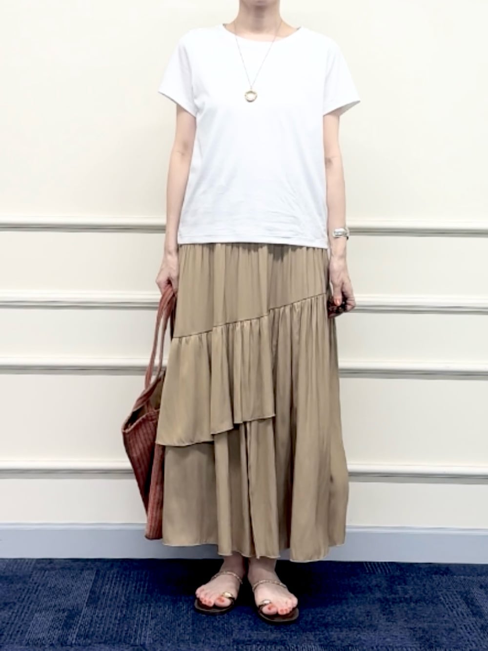 レッド系のトートバッグ、イエロー系のスカート、ホワイト系のTシャツ/カットソーを着用したレディースの夏コーディネートの8枚目の写真