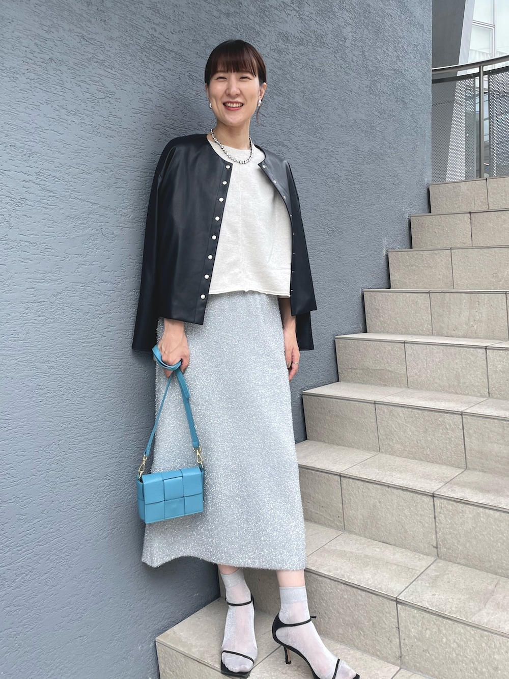 ブルー系のショルダーバッグ、ブラック系のサンダル、ブラック系のブルゾンを着用したレディースの秋コーディネートの8枚目の写真