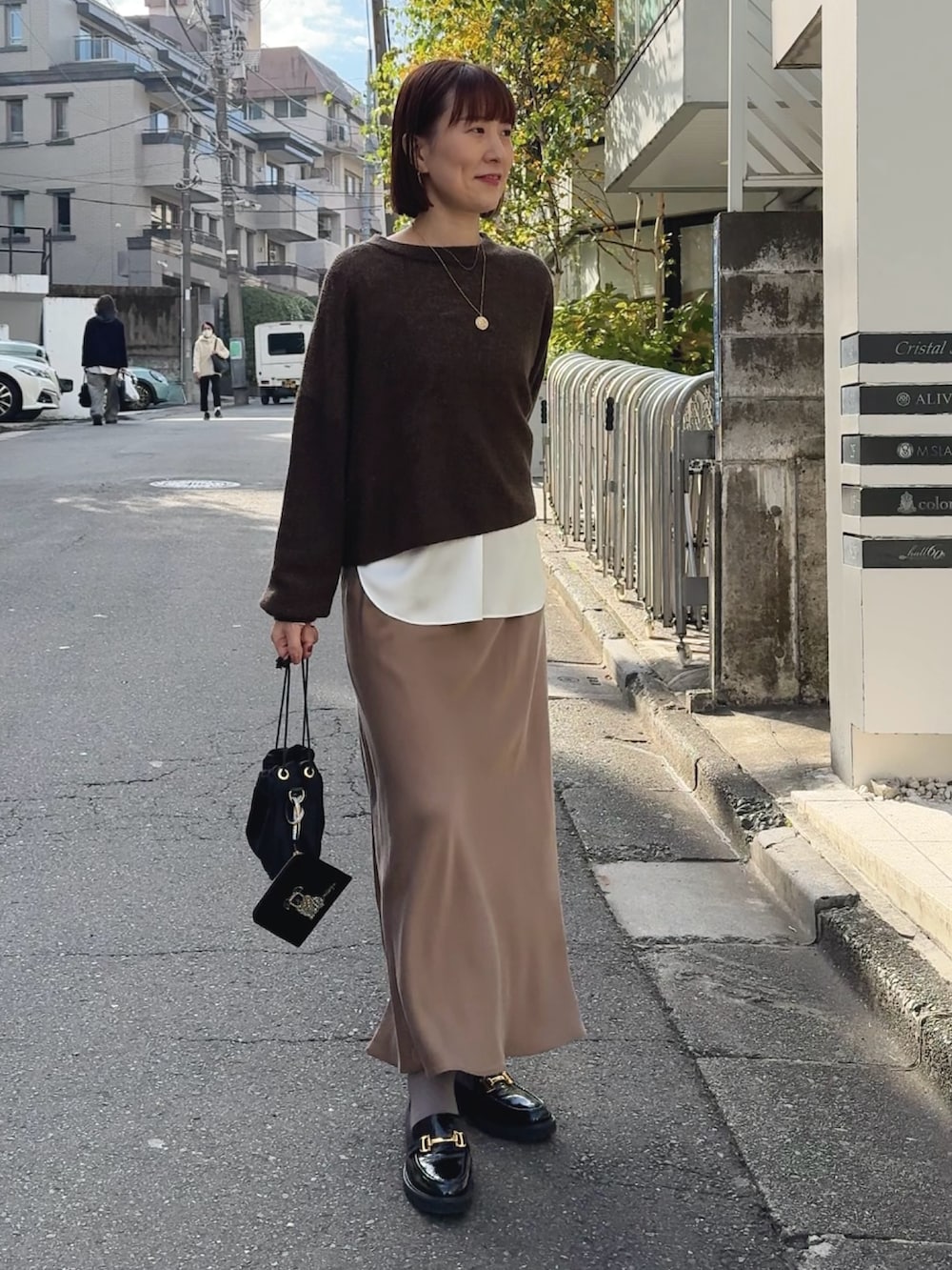 ホワイト系のシャツ/ブラウス、ブラウン系のニット/セーター、ブラック系のその他シューズを着用したレディースの冬コーディネートの6枚目の写真