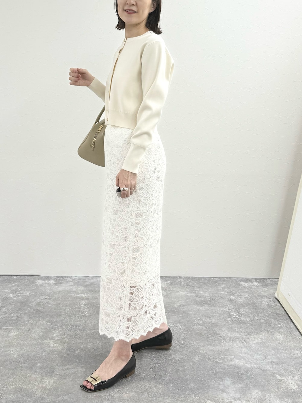ホワイト系のカーディガン/ボレロ、ベージュ系のショルダーバッグ、ホワイト系のスカートを着用したレディースの秋コーディネートの8枚目の写真
