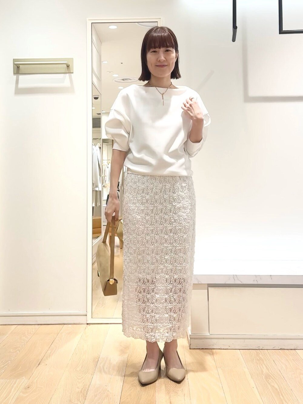 ホワイト系のTシャツ/カットソー、ホワイト系のスカート、ゴールド系のネックレスを着用したレディースの春コーディネートの7枚目の写真