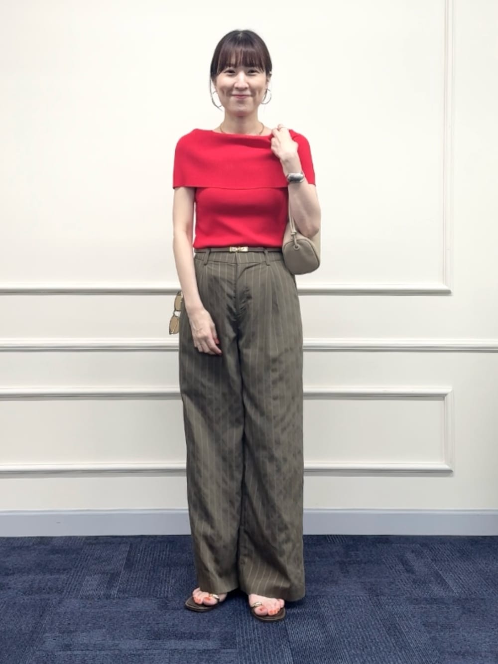 レッド系のニット/セーター、グリーン系のその他パンツ、ベージュ系のショルダーバッグを着用したレディースの夏コーディネートの9枚目の写真