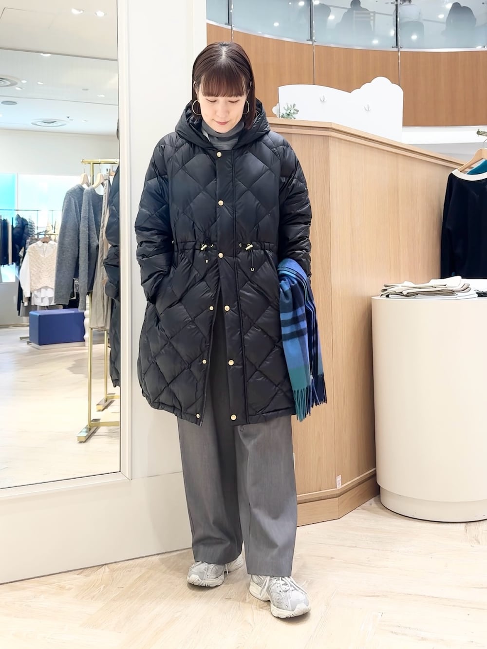 グレー系のその他パンツ、グレー系のニット/セーター、ブラック系のダウンジャケット/コートを着用したレディースの冬コーディネートの5枚目の写真