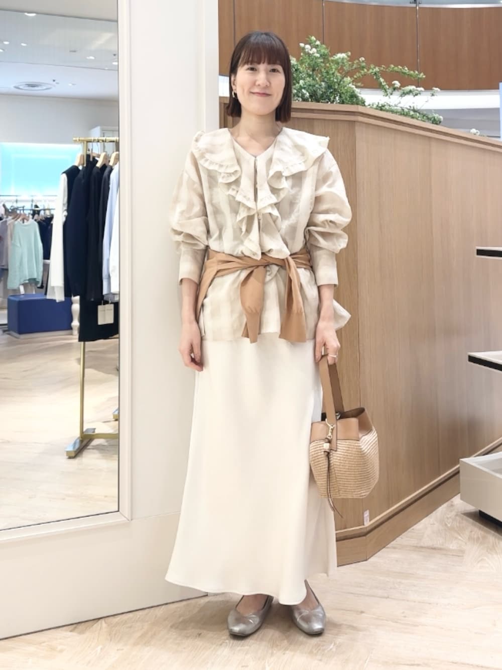 イエロー系のカーディガン/ボレロ、ホワイト系のシャツ/ブラウス、ベージュ系のショルダーバッグを着用したレディースの春コーディネートの7枚目の写真