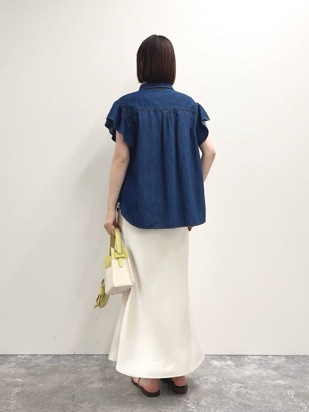 ブルー系のシャツ/ブラウス、イエロー系のショルダーバッグ、ホワイト系のスカートを着用したレディースの冬コーディネートの8枚目の写真